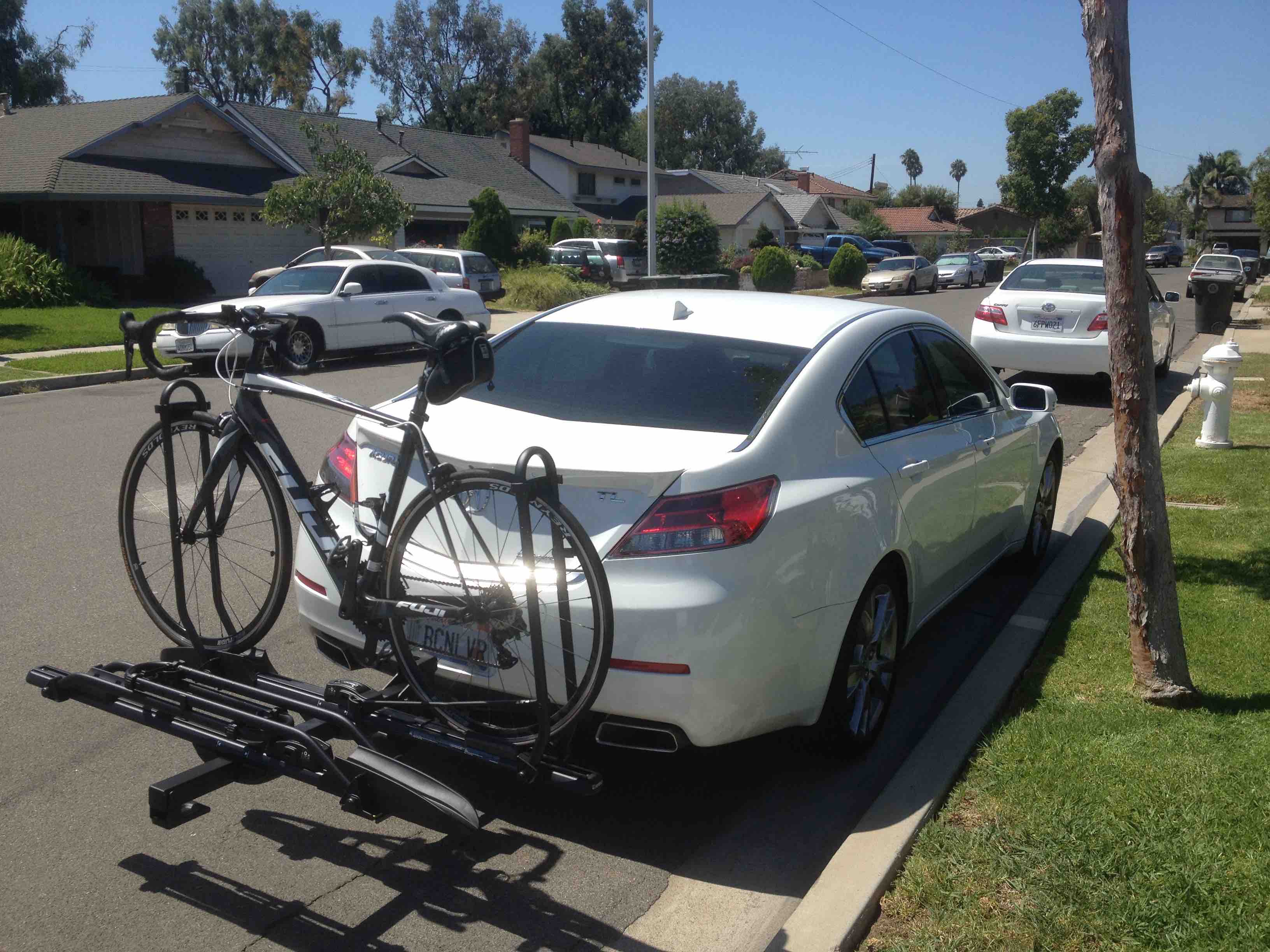 Hitch mounted bike rack with bicycle on back of sedan