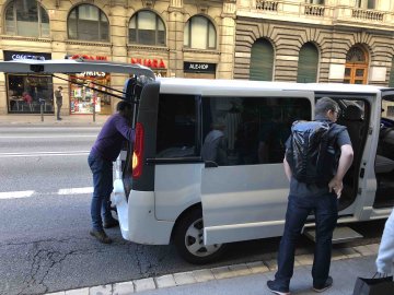 Cyclists unloading a van full of suitcases and bike boxes at the Grand Hotel Central in Barcelona, Spain