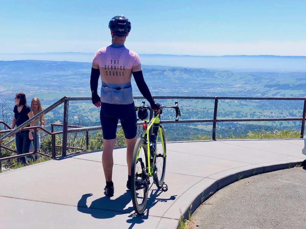 Cyclist wearing pro kit from The Service Course in Girona, Spain, at the top of Mount Diablo
