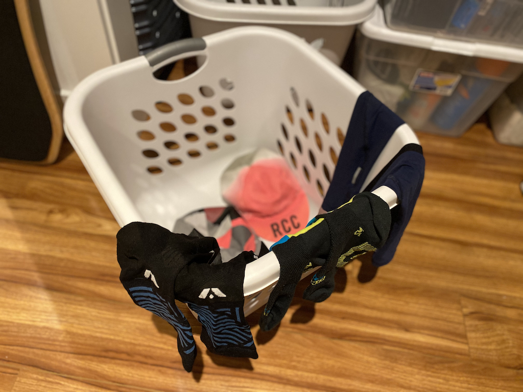 Cycling clothing hanging off the side of a laundry basket