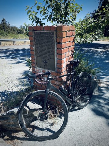 Factor O2 VAM bike with plaque about Mountain Charlie at the top of Mountain Charlie road