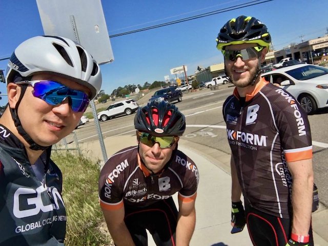 Three cyclists fixing a flat during the 2017 Solvang Century ride