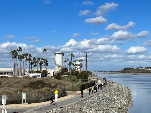 Cyclists getting on to the Santa Ana River Trail from Pacific Coast Highway near Huntington Beach, California