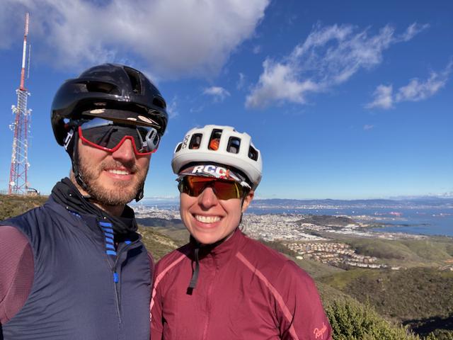 Two cyclists posing for a portrait at the top of San Bruno Mountain near the radio towers
