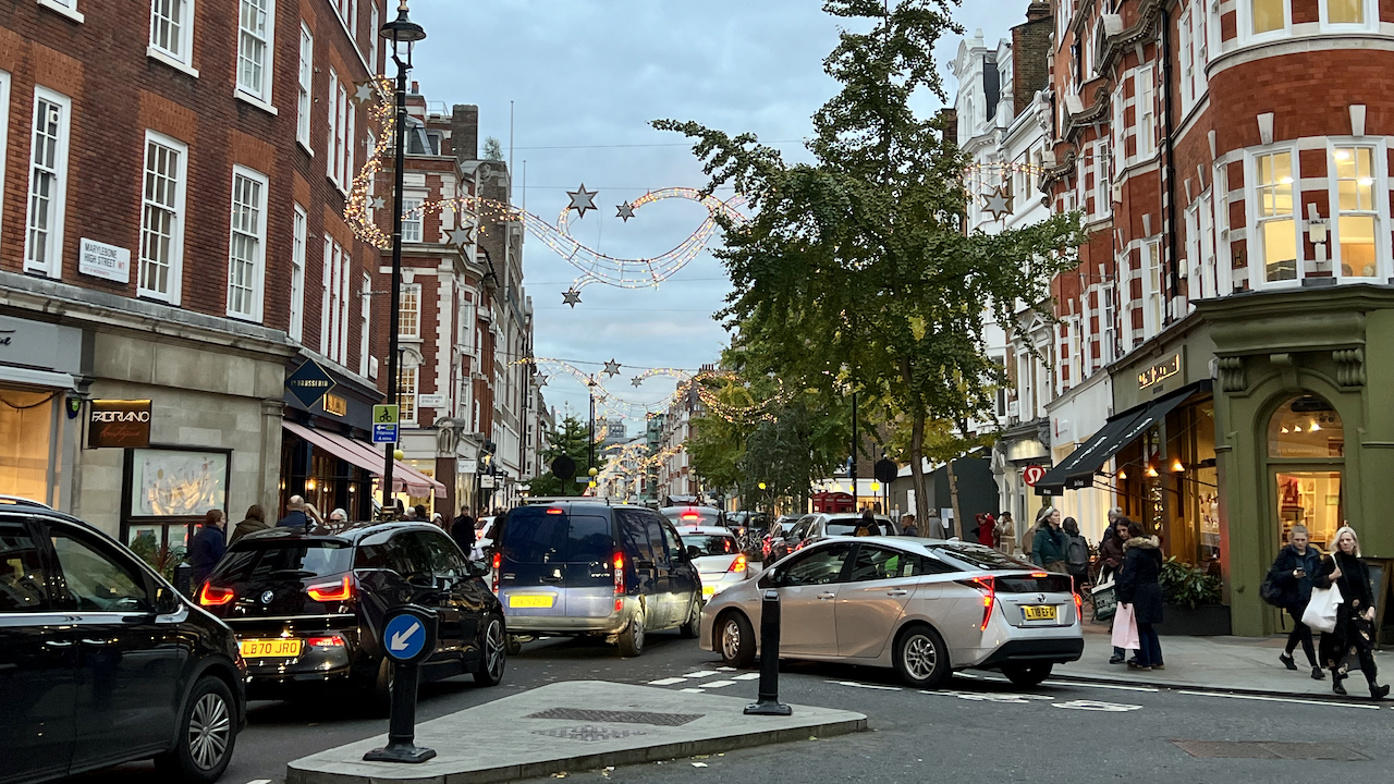 Cars in traffic along a small road in London