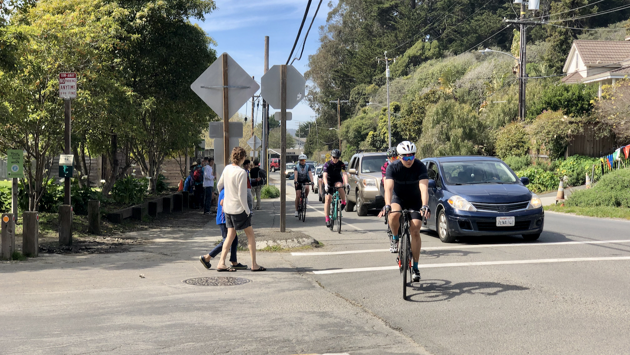 Cyclists, cars, and pedestrians sharing a common space in Stinson Beach, CA