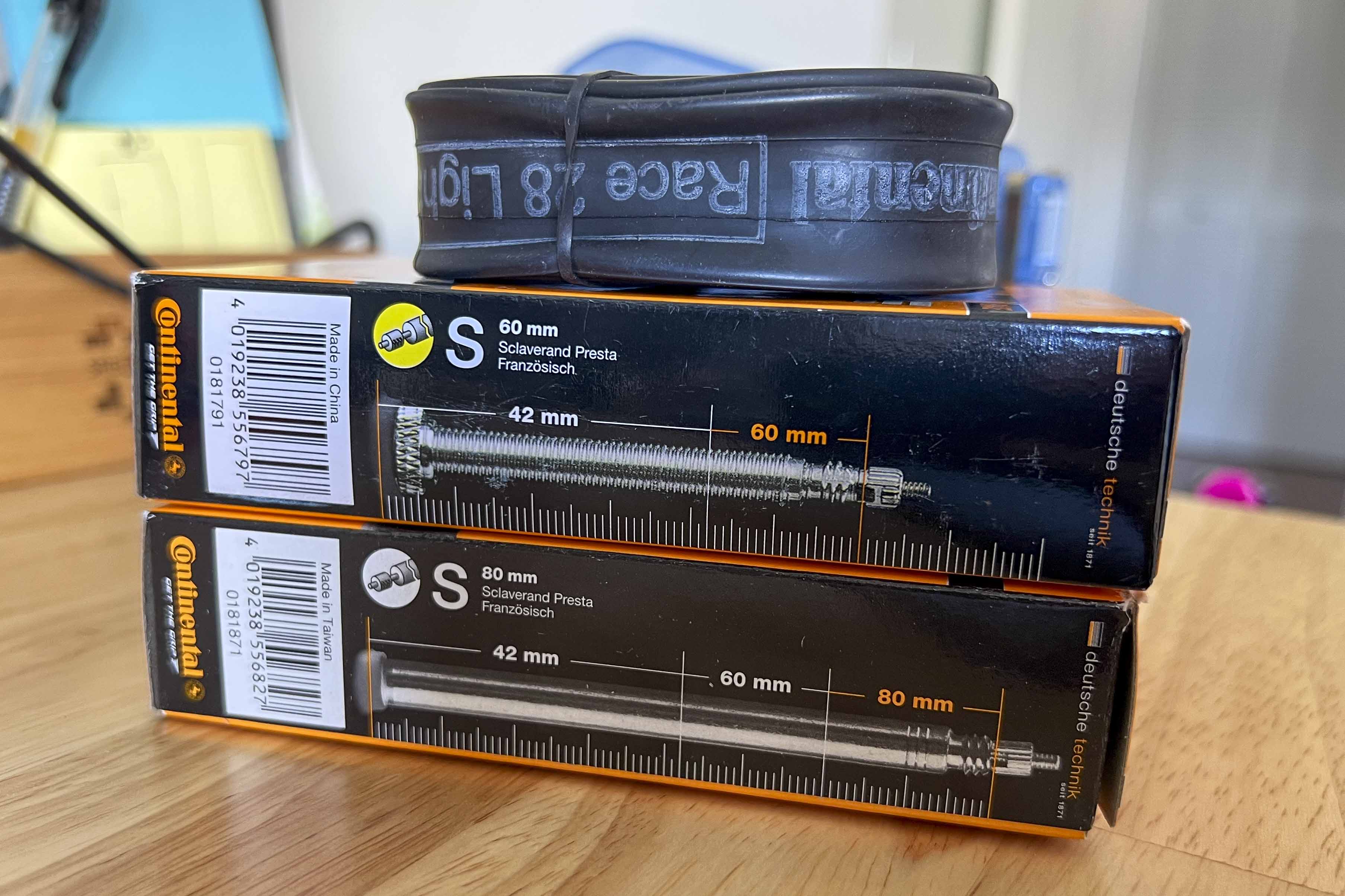 Stacked Continental branded bicycle tire tubes in boxes showing their valve stem lengths