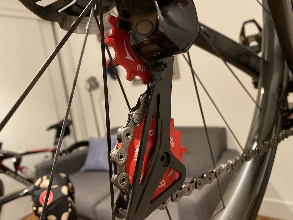 Red BBInfinite pulley wheels previously installed into a Shimano Dura Ace derailleur
