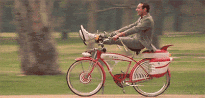Peewee Herman riding his bike without a care in the world