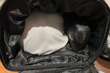 Inside view into the ScIcon Race Day Rain Bag with Sweet Protection Falconer helmet and one Rapha Pro Team shoe inside
