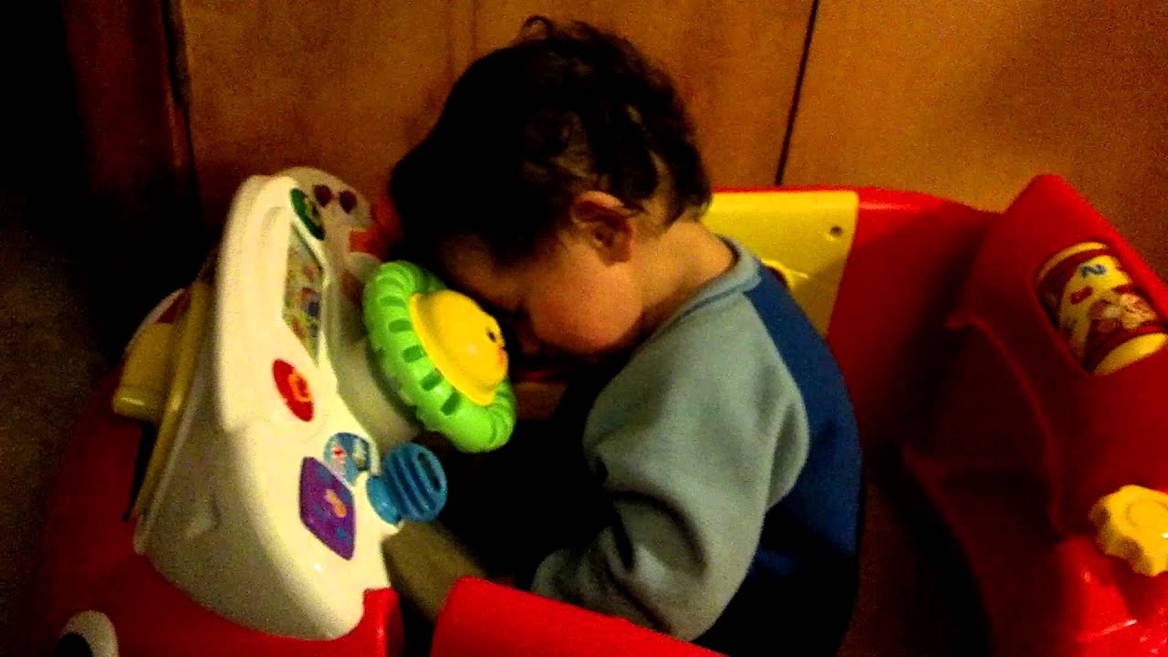 Toddler falling asleep at the wheel of his toy car
