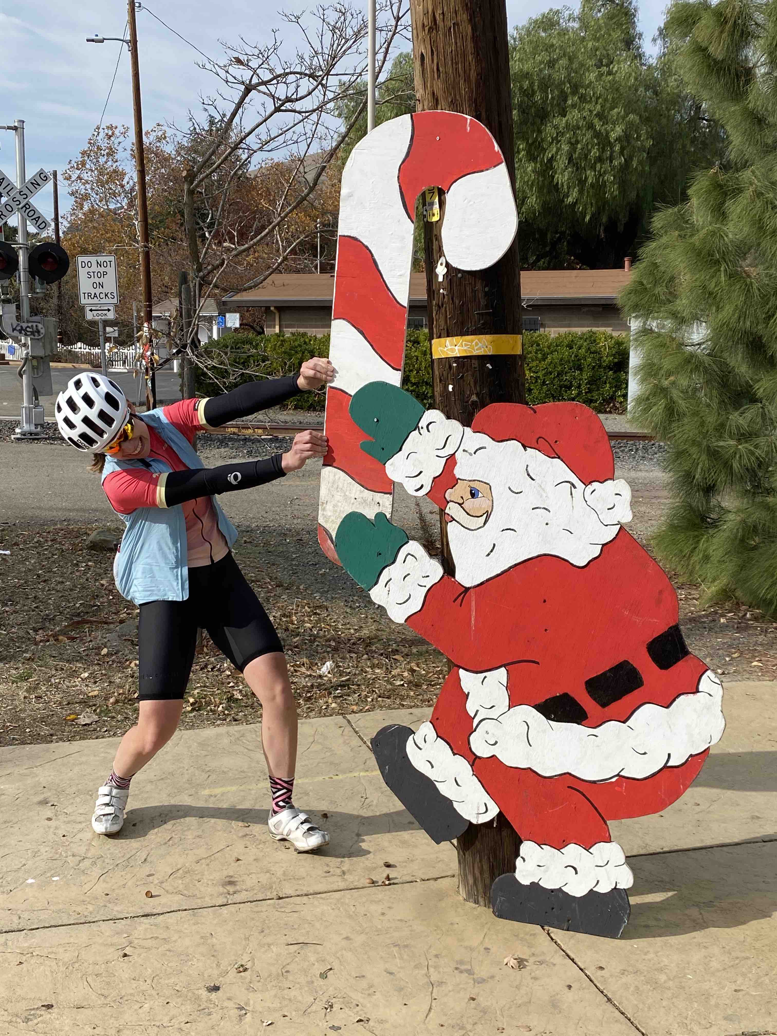 Cyclist playing tug of war with Santa Claus over a candy cane near Sunol, California
