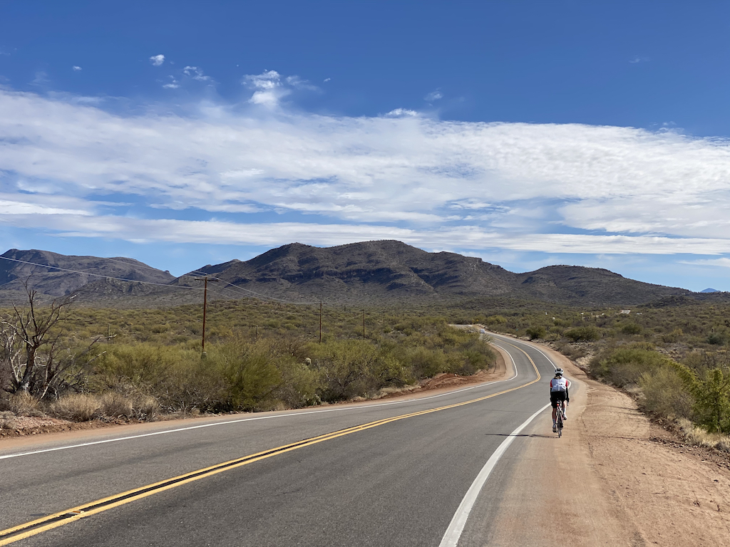 Lone cyclist traveling along winding road near the east side of Tucson, Arizona.