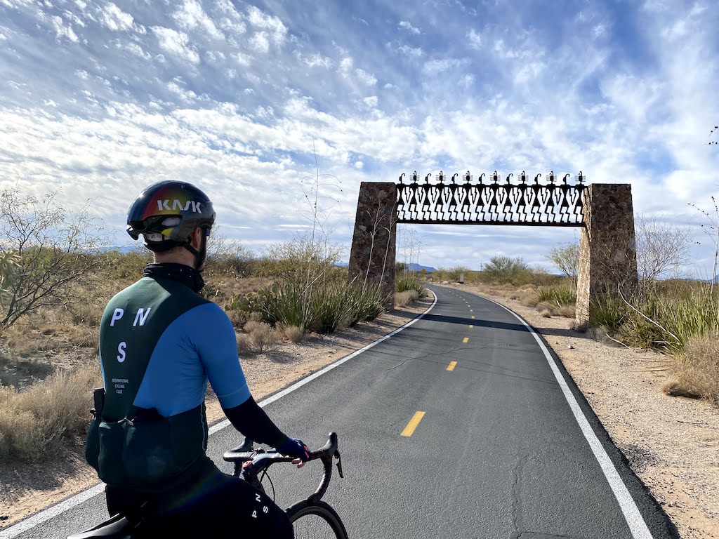 Cyclist looking out over the Joining Hands monument along the Julian Wash portion of the Loop trail in Tucson, Arizona