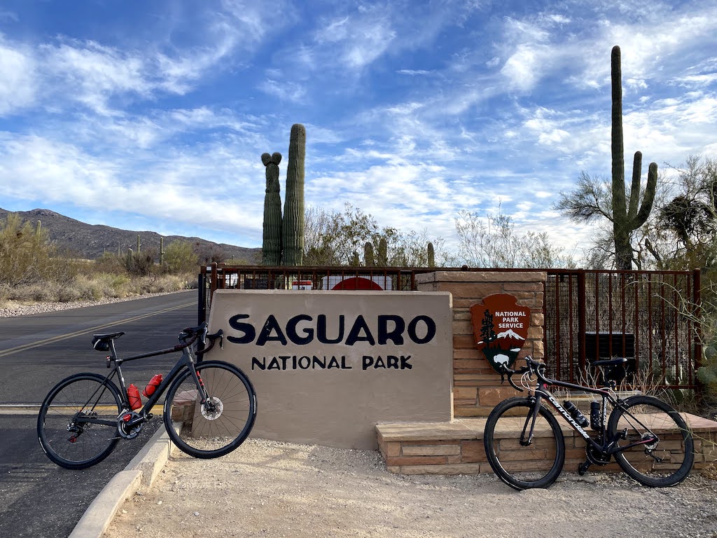 Bikes resting against the sign outside the entrance to Saguaro National Park East.