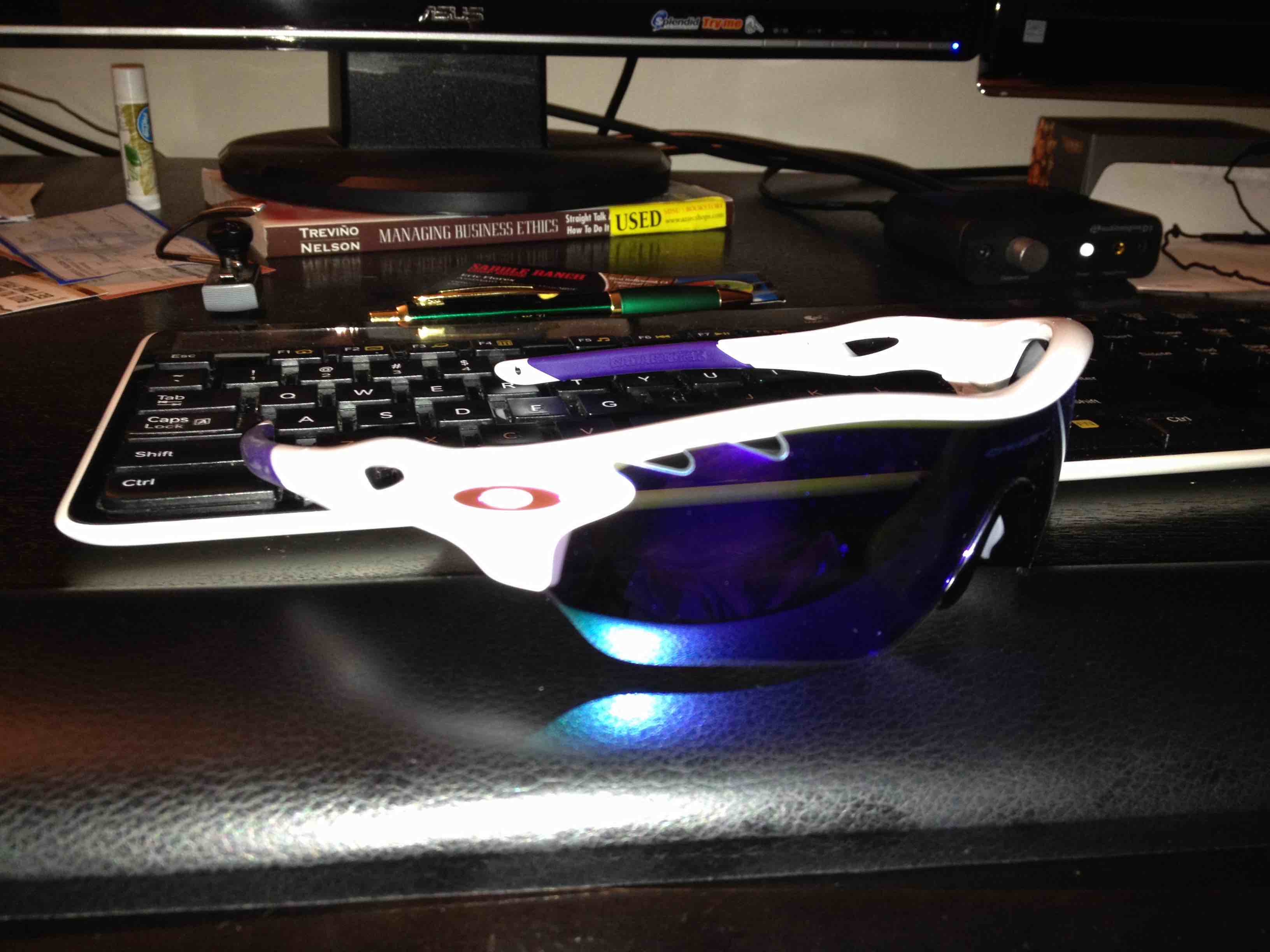 First pair of Oakley sunglasses on desk in front of keyboard