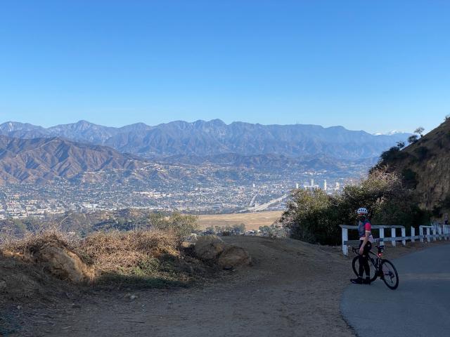 Cyclist at the top of the Hollywood Sign looking northwest towards the San Fernando Valley and the mountains behind it