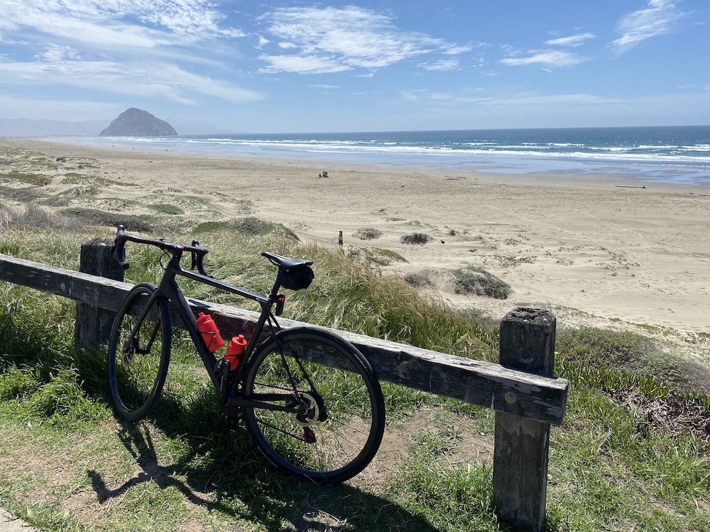Factor O2 VAM bicycle leaning against a fence overlooking the beach north of Morro Rock in Morro Bay, California