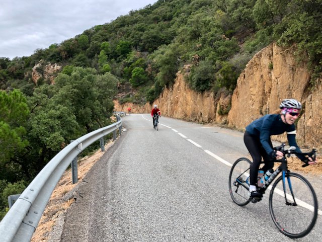 Smiling cyclists riding along the ocean in Costa Brava, Spain