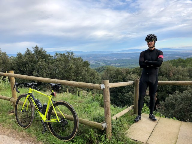 Cyclist standing with Giant TCR Advanced SL bike at the top of Els Ángels in Girona, Spain