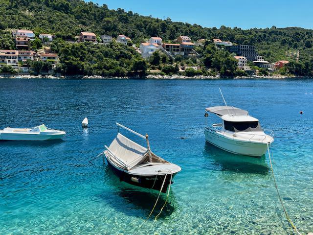 Boats docked in clear blue water at Brna, Croatia