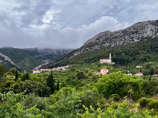 Church sitting upon a hill nestled up against the mountain on the island of Hvar, Croatia