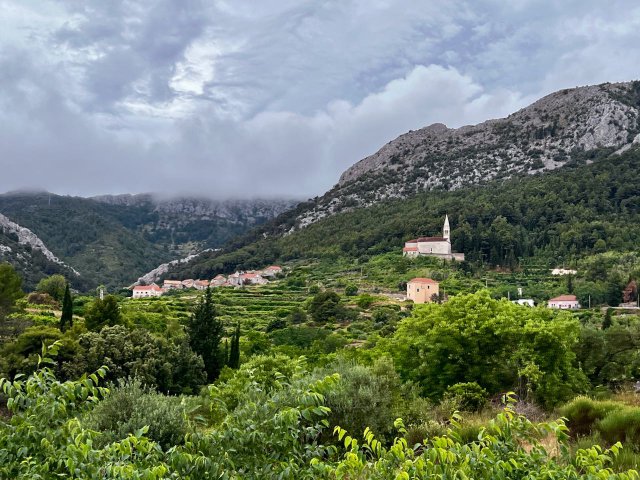 Church sitting upon a hill nestled up against the mountain on the island of Hvar, Croatia
