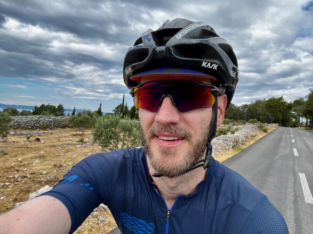 Cyclist smiling while riding through small towns on Hvar island