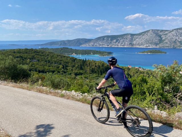 Cyclist looking out over the water on a descent in Croatia near Pupnat