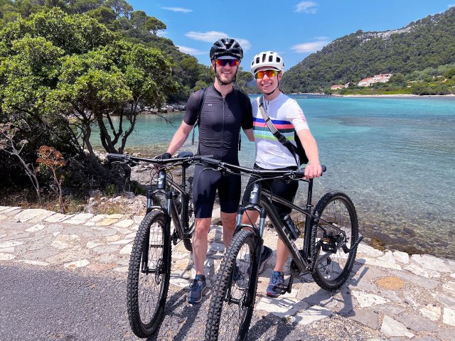 Two cyclists posing near the Venetian bridge in Mljet, Croatia