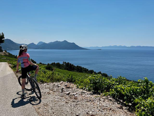 Cyclist standing on pedals overlooking the Adriatic along the Croatian peninsula
