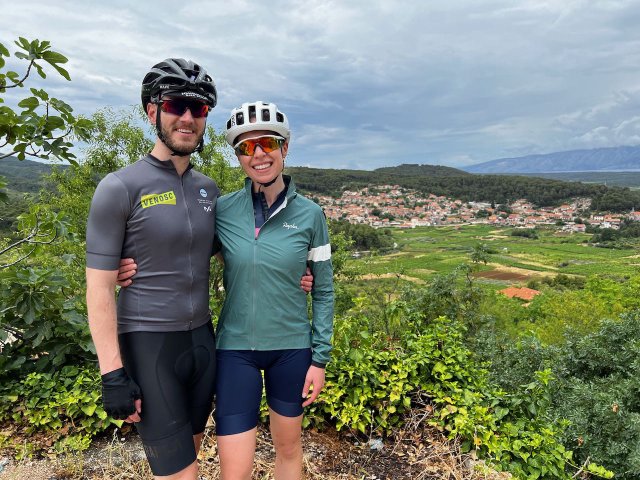 Two cyclists posing up near a church in Vrisnik, Croatia