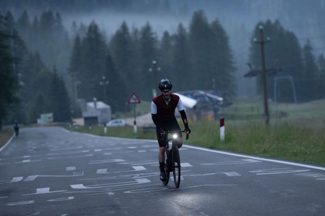 Intense looking cyclist climbing the Passo Fedaia in the morning hours