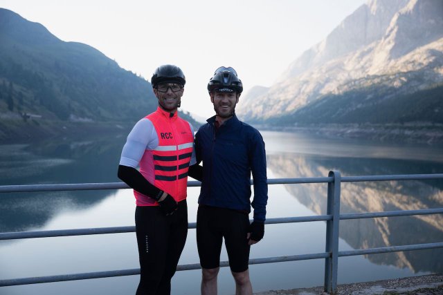 Two cyclists posing proud after having climbed up the Passo Fedaia
