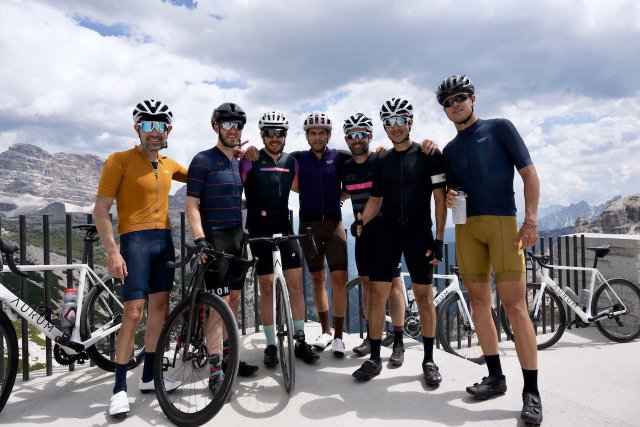 Group of cyclists posing at the top of the Tre Cime di Lavaredo climb