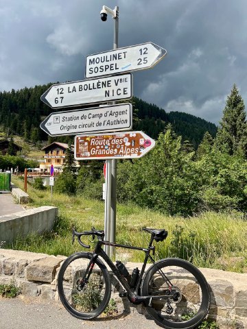 I certainly enjoyed putting my sticker up there with everyone else's! Bicycle next to sign at the top of Col de Turini with the Hôtel des Trois Vallees in the background