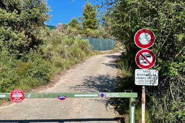 I mean, it looks innocuous enough, right? Gate leading to dirt path near the top of Mont Gros hiking and biking trail