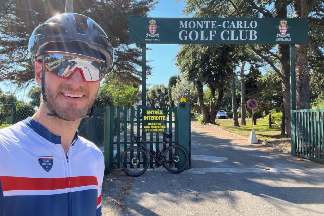 Portrait shot of cyclist in front of the Monte Carlo Golf Club gate on Mont Agel in Monaco