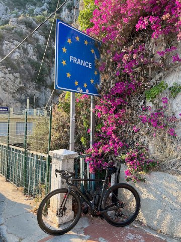 Bicycle in front of France border sign with Italy