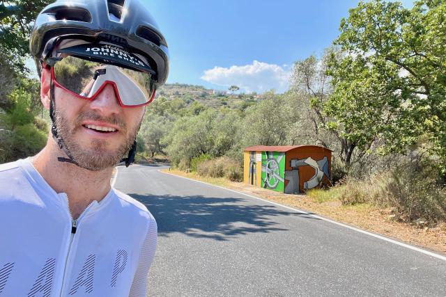 Cyclist selfie with a bike shed on the Cipressa climb in Italy
