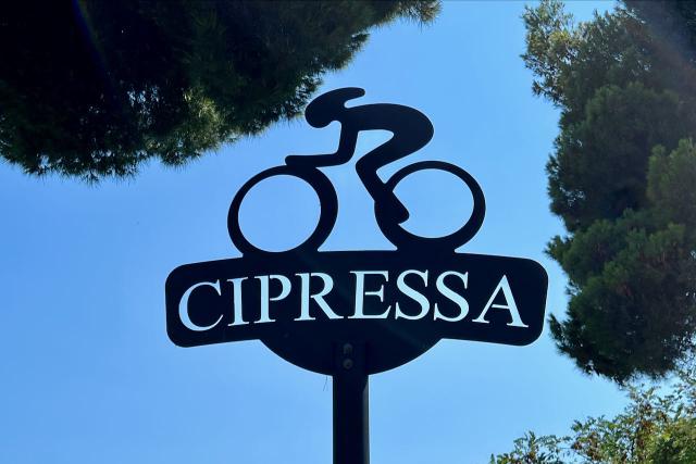 Iron sign showing a bike at the top of the Cipressa climb in Italy