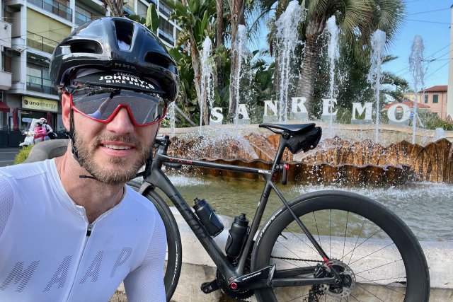 Cyclist selfie posing with bicycle in from the water fountain in Sanremo, Italy