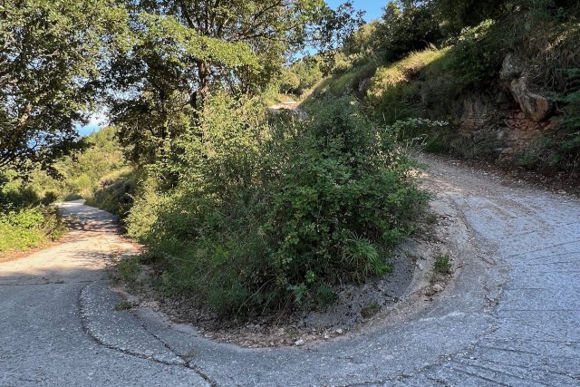 Bend in path of Via Aurelia near Roquebrune-Cap-Martin, showing only paved section with dirt on either side