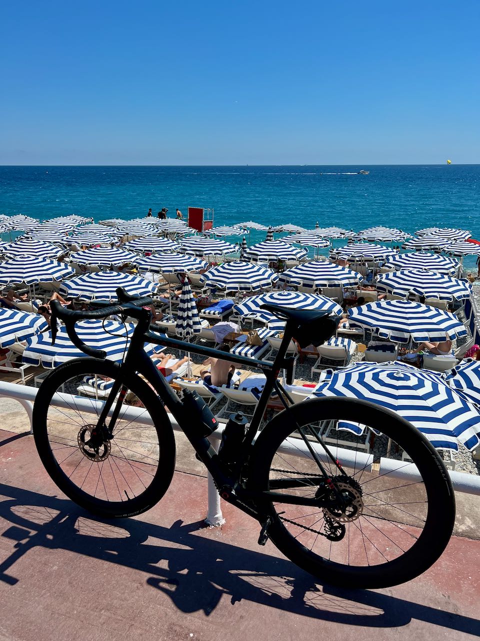 Road bicycle with blue umbrellas at the beach in Nice, France