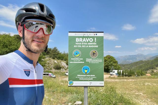 Cyclist portait with Bravo sign at the top of the Col de la Madone