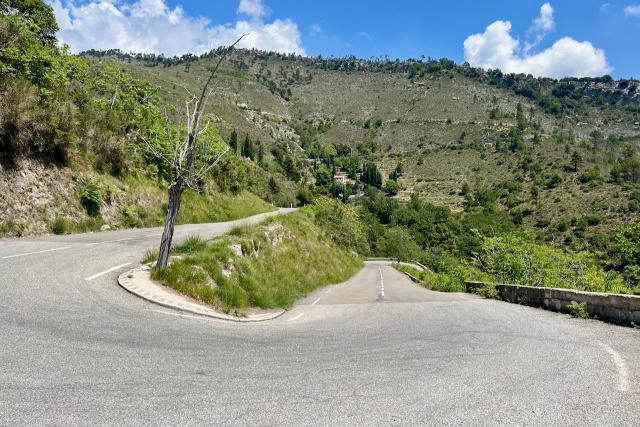 View overlooking one of the famous switchbacks on the Col de Braus showing the road bending up and down