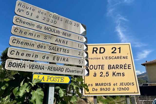 Close up picture of sign showing road closure times near L'Escaréne, France