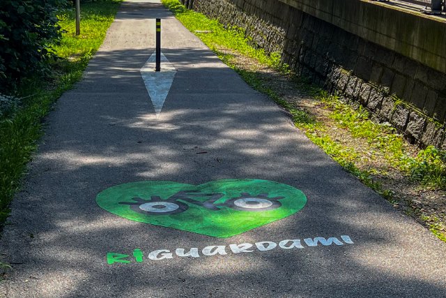 Street art showcasing Riguardami in writing along a bike path near Lugano, Switzerland