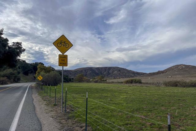 Green view with yellow bike sign along East Otay Lake Road near Jamul, California