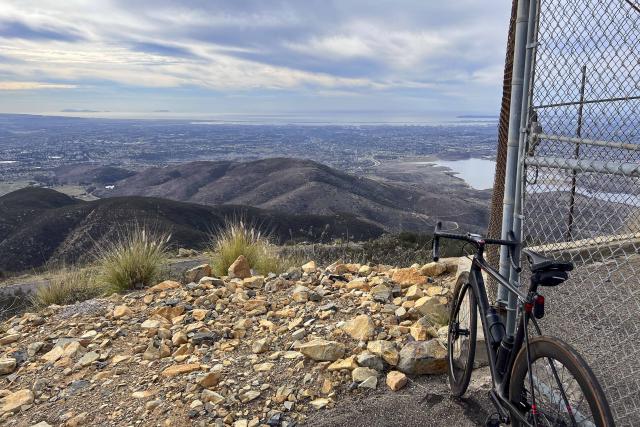 Bike leaning against fence at the top of San Miguel Mountain with views over San Diego Bay